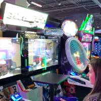 Two alumni playing arcade game